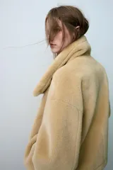 Cazadora reversible de cuello subido y manga larga, con bolsillos de vivo en el delantero y cierre frontal con botones. Confeccionada en tejido combinado con efecto pelo y efecto ante.