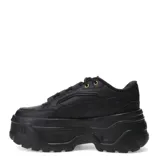 Championes urbanos Puma modelo Karmen X-TRA, color negro con plataforma alta y detalles en dorado en los ojales. Presentan un diseño robusto con suela dentada y cordones al tono.