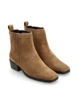 Bota de gamuza color marrón claro, de caña baja con elásticos laterales y lengüeta posterior. Presenta punta cuadrada y taco ancho.