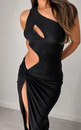 Vestido largo negro de un solo hombro con diseño cut-out en el torso y abertura lateral profunda en la falda. Presenta un detalle de nudo en la cintura que genera un efecto drapeado.