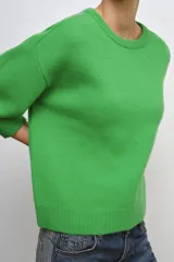 Jersey de punto liso confeccionado en lana 100%, con cuello redondo y mangas que llegan por debajo del codo.