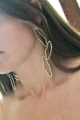 Aros colgantes de diseño orgánico, compuestos por tres eslabones de formas irregulares entrelazados, realizados en bronce.