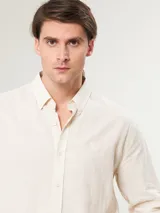 Camisa de manga larga color verde claro, con cuello clásico y cierre frontal con botones.