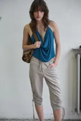 Pantalón capri de tiro medio con efecto lavado, bolsillos delanteros y traseros, y bajo con frunces laterales ajustables mediante cordones.
