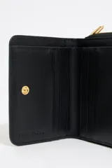 Billetera negra charolada con cierre dorado y logo de la marca Bimba y Lola estampado en dorado.