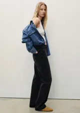 Jeans de tiro alto y diseño recto en color negro lavado. Cuenta con cinco bolsillos, trabillas para cinturón y cierre frontal con cremallera y botón metálico.