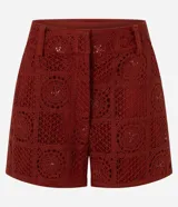 Short corto de crochet Marfinno color rojo, con diseño calado, bordado abstracto integral, aplicación de lentejuelas, pretina con pasadores y cierre delantero. Cuenta con forro interior.