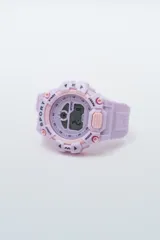 Reloj digital deportivo de color lila con correa de silicona y diseño robusto. Cuenta con pantalla LCD, funciones de cronómetro, luz de fondo y es resistente al agua.