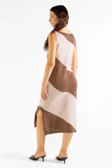 Vestido midi de punto sin mangas, con diseño a rayas diagonales en tonos marrón y tostado con hilo metalizado. Cuenta con escote bote, corte recto y abertura lateral en el dobladillo.