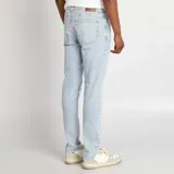 Jean slim de hombre color azul claro, con cinco bolsillos y cierre de botón y cremallera.