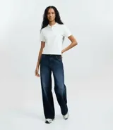 Blusa estilo polo de manga corta, confeccionada en tejido piquet color bordó. Presenta cuello clásico y cierre frontal con tres botones.