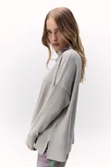 Suéter de punto color naranja, con cuello alto y mangas largas.