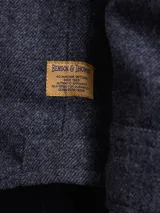 Overshirt de textura tipo tweed en color marrón, con cuello clásico, cierre frontal de botones y bolsillo en el pecho.