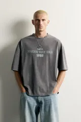 Remera de corte relaxed fit con efecto lavado, cuello redondo y manga corta, con estampado frontal contrastante.
