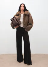 Jeans wide leg tiro alto de pana marrón oscuro, con diseño de cinco bolsillos, trabillas para cinto y cierre frontal con botón y cremallera.