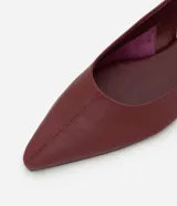 Zapatilla tipo slingback de cuero color marrón oscuro, con diseño de punta fina y talón descubierto con tira de ajuste.