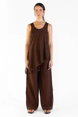 Pantalón ancho de color marrón, con pretina elástica, bolsillos laterales y aberturas en los bajos. Confeccionado en tejido fluido.