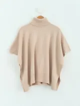 Poncho de tejido de punto color marrón chocolate, con cuello alto tipo polera y mangas cortas amplias. Presenta un diseño holgado con terminaciones acanaladas en el ruedo.