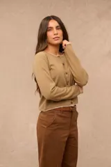 Saco tejido color taupe de manga larga, con escote redondo y cierre frontal de botones. Presenta detalles de costura en color blanco en el cuello, puños y ruedo.