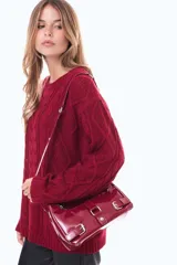 Buzo tejido de punto con diseño de trenzas, color negro, de corte holgado, cuello redondo y mangas largas.