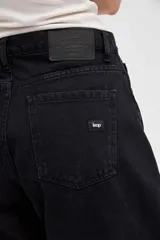 Jean de tiro alto con silueta tipo globo, de cintura ajustada y piernas holgadas que se estrechan hacia el bajo.