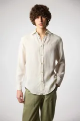 Camisa de lino color crudo, de manga larga y corte clásico.
