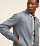 Chaqueta bomber azul marino lisa, con cierre frontal, cuello redondo y bolsillos laterales.