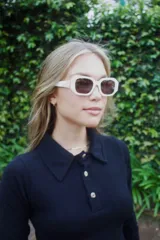 Sweater de punto fino en color verde oscuro, con cuello polo y cierre frontal de tres botones. Presenta mangas largas y un ajuste al cuerpo.