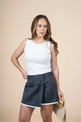 Short pollera de diseño cruzado con estampado de rayas finas en tono gris oscuro y detalle de borde blanco en el ruedo.