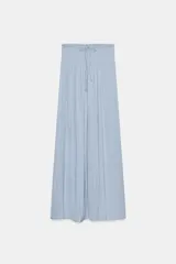 Falda larga celeste de tiro alto con cintura elástica tipo nido de abeja y cordón ajustable.