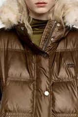 Chaqueta acolchada corta de tejido técnico brillante en color rojo, con cierre frontal de cremallera y botones de presión. Presenta capucha con borde de pelo sintético desmontable, bolsillos laterales con cremallera y puños de punto elástico en color rojo.