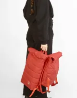 Mochila acolchada color beige con cierre superior enrollable y hebilla.