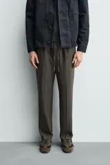 Pantalón regular fit color negro de tejido con viscosa, con cintura elástica ajustable con cordón, bolsillos frontales y traseros.