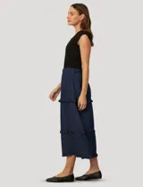 Pollera larga de lyocell en color azul, con diseño de paneles escalonados y volados en cada costura. Presenta cintura elástica fruncida para mayor comodidad.