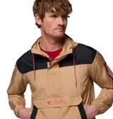 Chaqueta tipo cortaviento Columbia con diseño de media cremallera y capucha ajustable. Presenta un bolsillo frontal grande con solapa y un bolsillo adicional con cierre en la manga. Combina tonos beige y negro, con tecnología Omni-Shield que repele la humedad y las manchas.