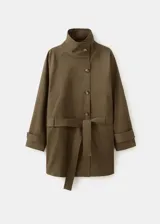 Chaqueta de gabardina color verde militar, de corte oversize con cuello alto abotonado de manera asimétrica, mangas largas con puños ajustables y cinturón ajustable del mismo tejido.