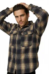 Sobrecamisa de franela a cuadros en tonos marrón, azul marino y beige, de manga larga, con bolsillos frontales con solapa y cierre de botones.
