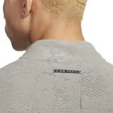 Buzo deportivo gris de tejido suave con tecnología Dri-FIT, cuello alto con media cremallera, mangas largas y bolsillo frontal.