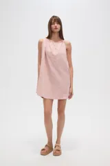 Vestido corto color rosa pálido con rayas verticales rojas, sin mangas, de corte ancho y cuello recto.