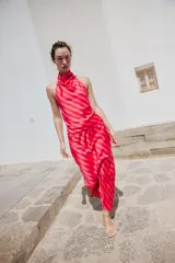 Top satinado sin mangas con cuello halter y estampado de rayas diagonales en tonos rojo y rosado.