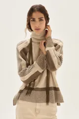 Polera de cuello alto confeccionada en lana lambswool, con diseño de bloques de color en tonos beige y marrón. Presenta mangas raglán con textura acanalada y detalles en hilo metalizado lurex.