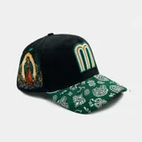 Gorra tipo trucker negra con visera verde estampada con diseño paisley en blanco. Presenta un logo bordado con la letra M en el frente y un bordado detallado de la Virgen de Guadalupe en el lateral.