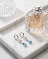 Caravanas colgantes de plata 925 con diseño de doble gota, una superior con pavé de circonias blancas y una inferior con una circonia central color celeste.