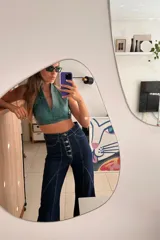 Top corto de cuero ovino color verde azulado con textura vintage, cuello halter y espalda descubierta con cierre de hebilla metálica. Combina con falda a juego.