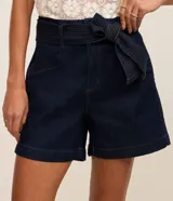 Short tipo mom de jean azul marino con cintura alta, bolsillos delanteros y cinturón ajustable confeccionado en la misma tela con pespuntes visibles.