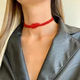 Gargantilla corta de cuentas rojas con nudo central.