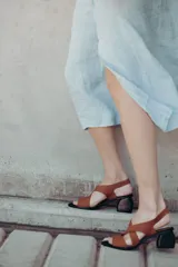 Sandalias de neopreno color marrón con tiras cruzadas en el empeine y puntera abierta. Cuentan con un taco irregular de 6 cm de altura y plantilla de cuero.