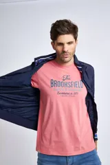 Campera liviana de nylon color gris oscuro, con cierre frontal completo, cuello subido y puños y cintura acanalados con rayas en rojo y blanco. Presenta logo bordado en el pecho y bolsillos laterales con cierre.