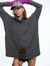 Buzo tejido de silueta holgada con cuello alto, diseño de rayas horizontales y tajos laterales en el ruedo.