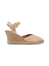 Sandalia de cuña color beige con plataforma de yute, capellada de cuero napa y tira ajustable al tobillo con hebilla forrada.